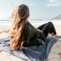 Woman laying on Pocket Blanket on sandy beach