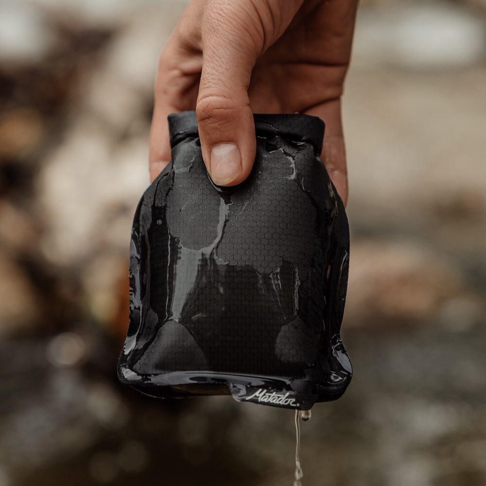 Hand holding soap bar case with water dripping from it