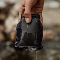 Hand holding blue FlatPack with water dripping off