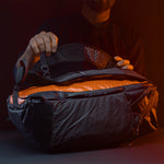 Man in dark studio, showing side view of edx backpack