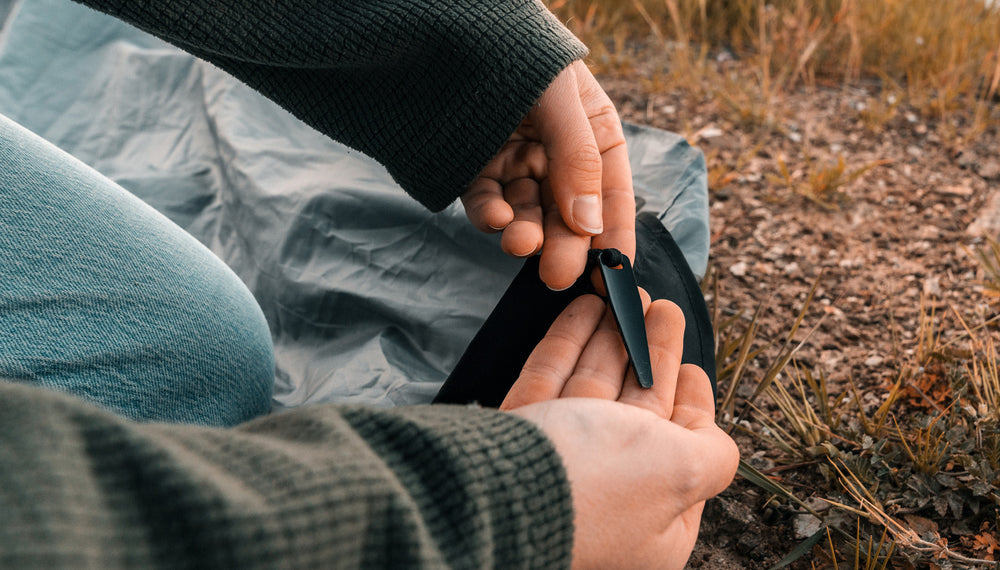 Close up view of woman holding the pocket blanket's ground stake