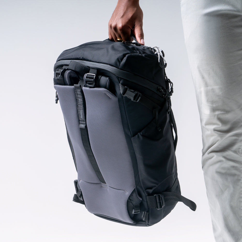 Black globerider35 with packed away shoulder and hip straps, being held at a man's side