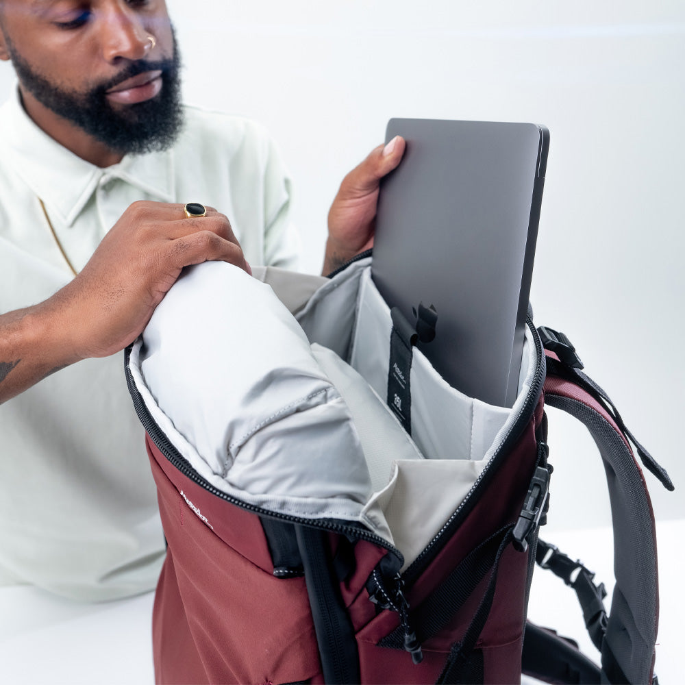 Man pulling laptop out of pocket inside garnet globerider35