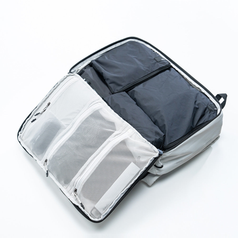 Open clamshell of arctic white globerider35, revealing black packing cubes.