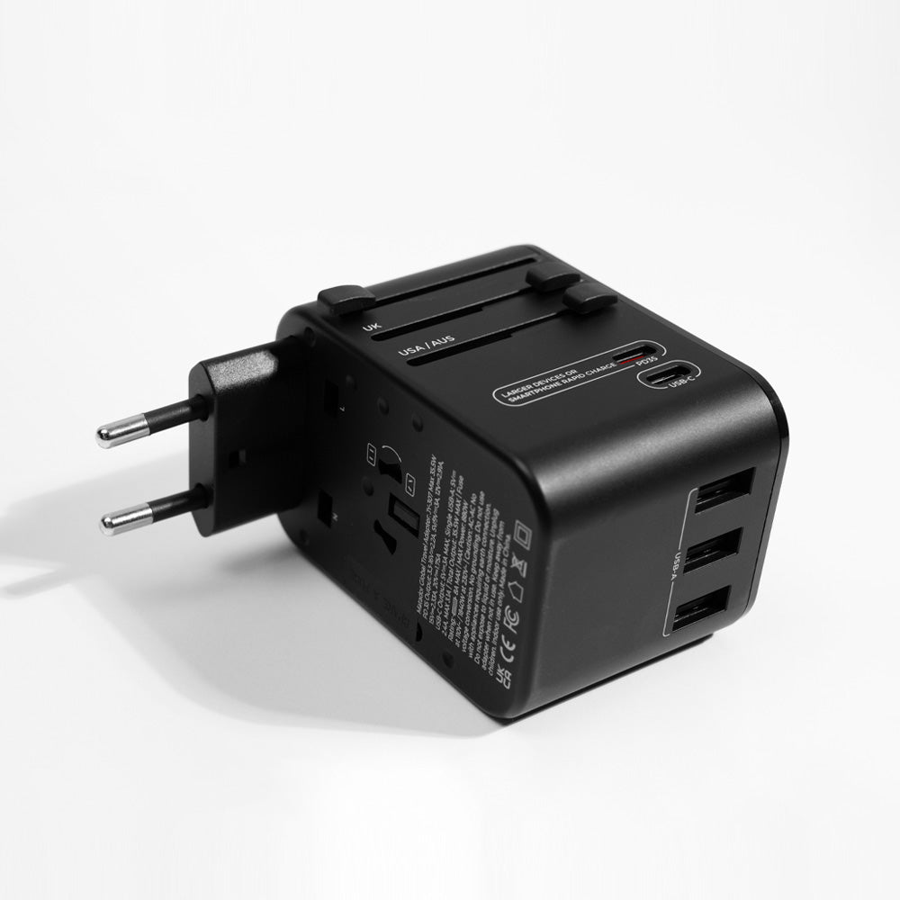 Black travel adapter laying on its side with EU prongs engaged, white background