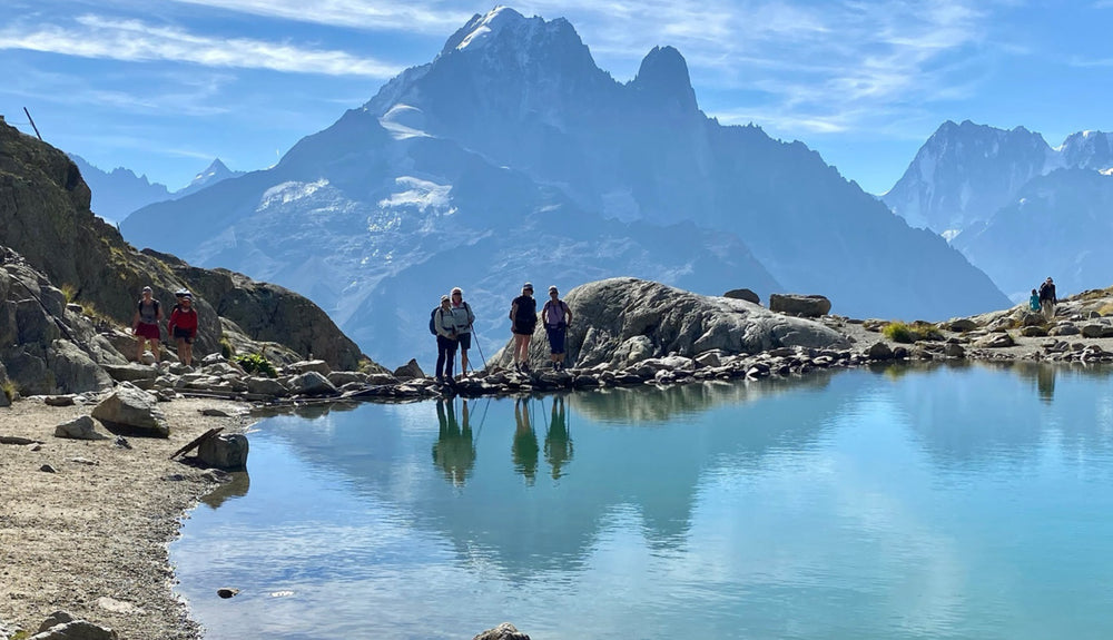 Hikers in mountain region in front of turquoise lake