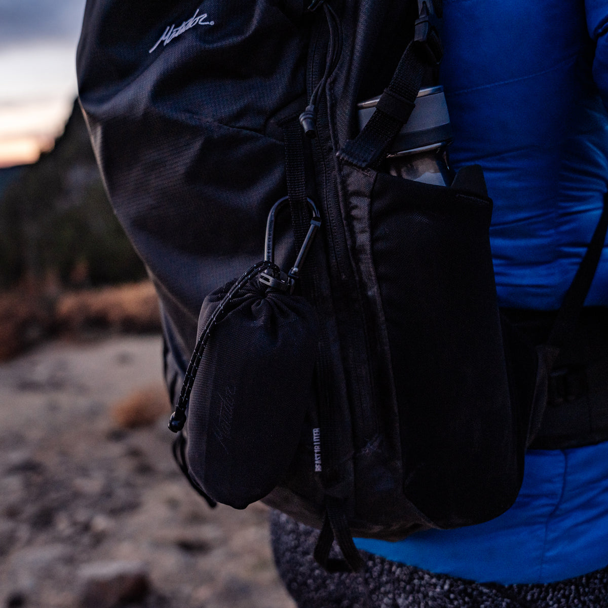 Towel pouch hanging from backpack by carabiner 