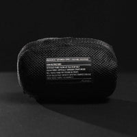 Packed down backpack pouch on black background