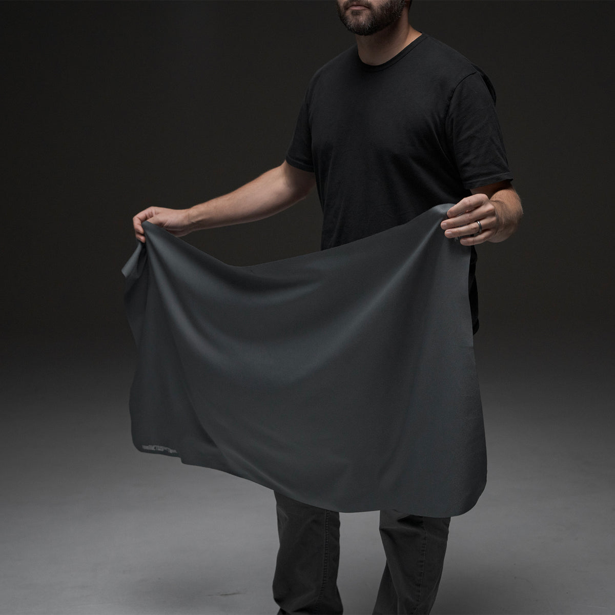 Man holding open towel on black